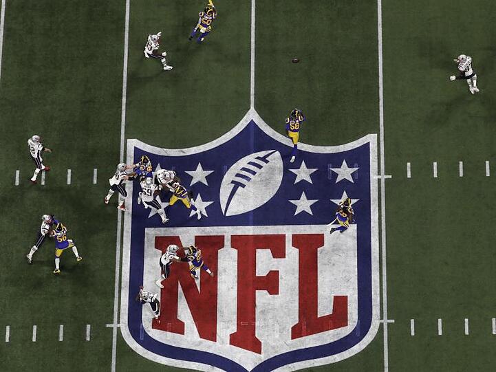 Spieler der us-amerikanischen NFL-Profiliga laufen über ein Footballfeld. Foto: Morry Gash/AP/dpa/Archivbild