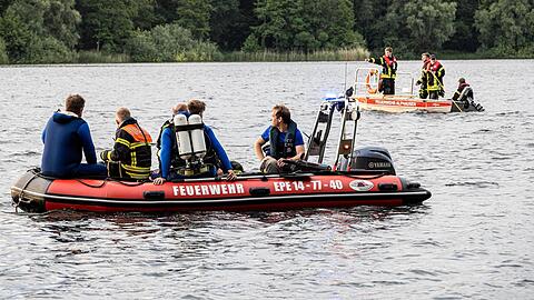 Helfer suchen mit Booten und Tauchern nach einem vermissten Schwimmer.