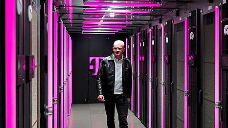 Andreas Falkner, verantwortlich f&uuml;r die KI-Fabrik, f&uuml;hrt durch das neue Rechenzentrum.