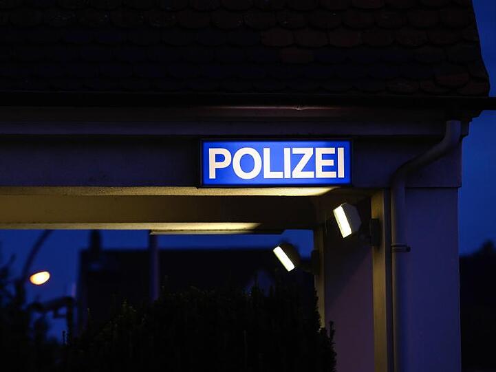 Ein Schild mit der Aufschrift "Polizei" leuchtet am Eingangsbereich der Polizeistation. Foto: Silas Stein/dpa/Archiv