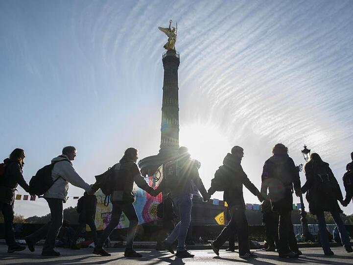 Extinction-Rebellion-Aktivisten tanzen um die Siegessäule in Berlin.