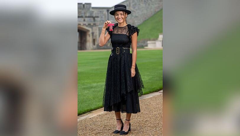 Strahlend präsentiert Emma Raducanu im Dior-Outfit ihren MBE-Orden.