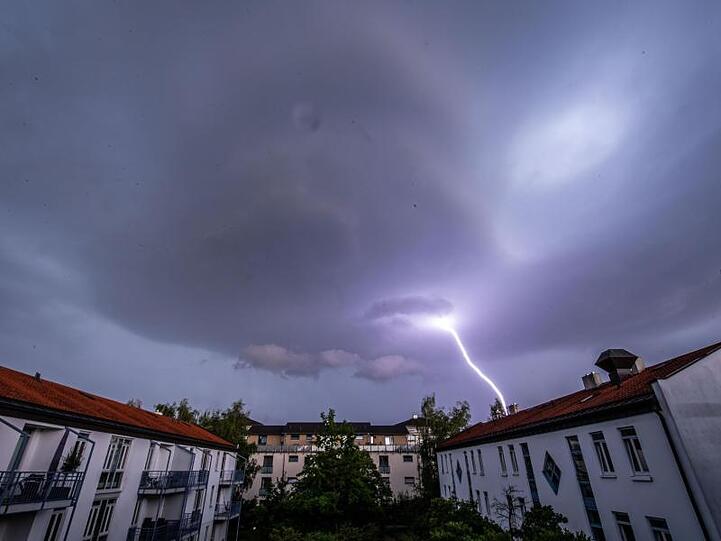 Ein Blitz schlägt in der Ferne ein. Foto: Lino Mirgeler/dpa/Archivbild