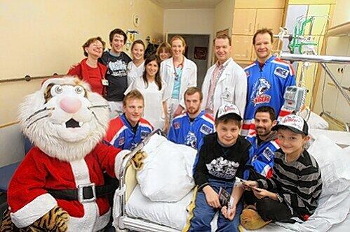 Gruppenbild mit kleinen Patienten (vorne rechts): Vier Ice Tiger, Maskottchen Pucki und das Team der Fürther Kinderklinik.