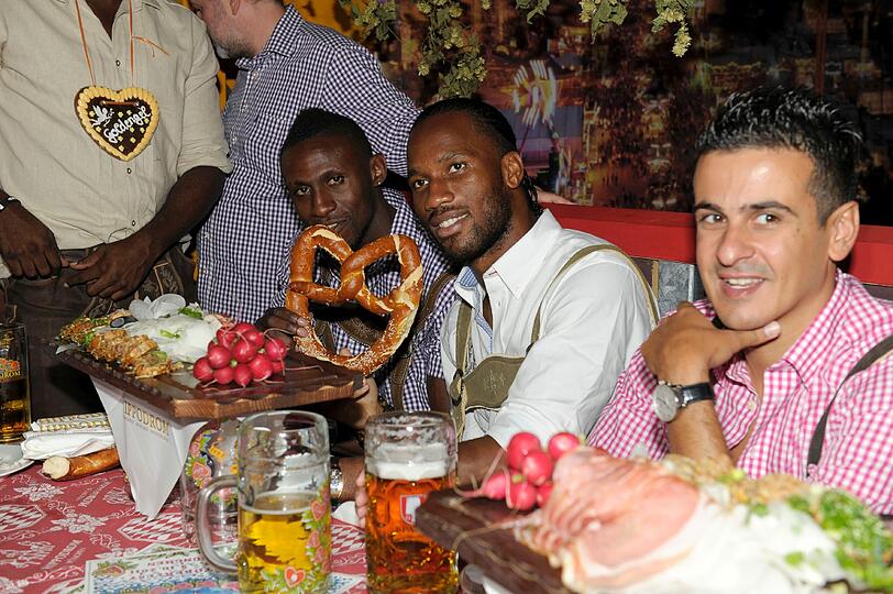 ... und scheint die Schmankerl der bayerischen Küche zu kennen: Fußballspieler Didier Drogba vom FC Chelsea, hier in der Mitte mit Breze.