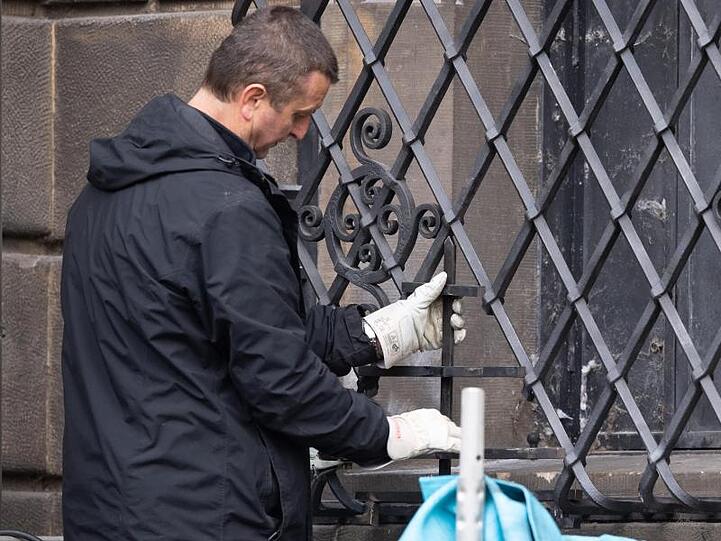 Ein Mitarbeiter einer Restaurierungsfirma arbeitet an dem bei einem Einbruch durchtrennten Gitterfenster des Grünen Gewölbes.