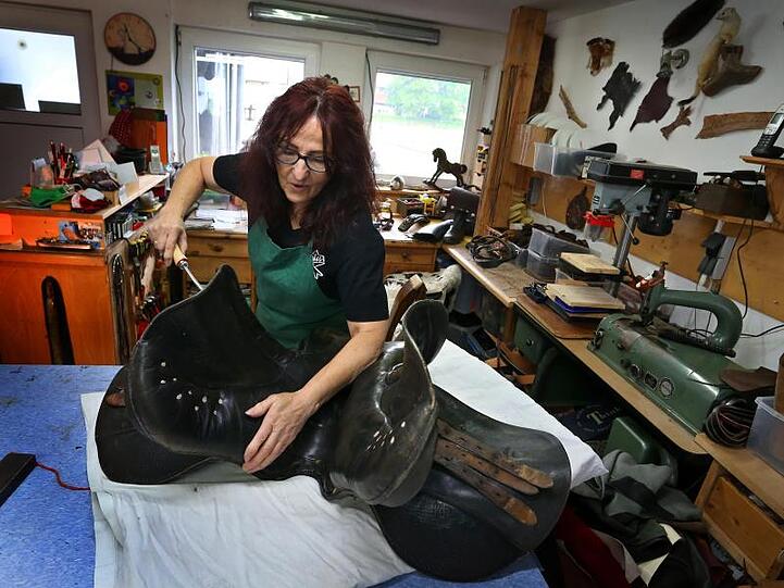 Marlies Bek stopft in ihrer Werkstatt einen Ledersattel mit Füllmaterial. Foto: Karl-Josef Hildenbrand/dpa/Archivbild