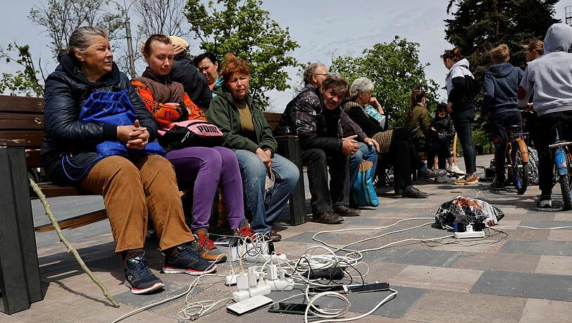 Menschen in Mariupol laden ihre Telefone auf - das Gebiet in der Ostukraine steht unter der Regierung der sogenannten Donezker Volksrepublik.