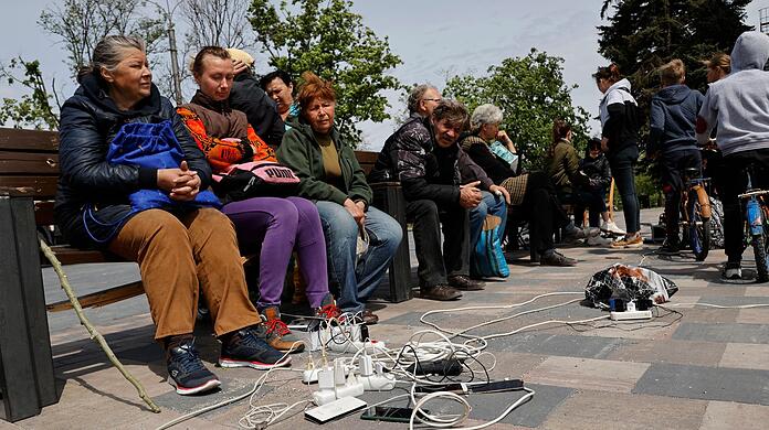 Menschen in Mariupol laden ihre Telefone auf - das Gebiet in der Ostukraine steht unter der Regierung der sogenannten Donezker Volksrepublik.