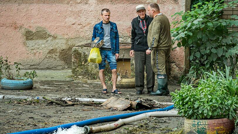 Mit Schläuchen wird das Wasser aus den überfluteten Häusern in Cherson gepumpt. Mit Schläuchen wird das Wasser aus den überfluteten Häusern in Cherson gepumpt.