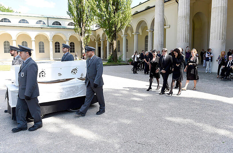 Vier Sargträger bringen den weißen Sarg (mit schwarzen Käfern), wie es sich der Feinkost-König gewünscht hat, zum Friedhof.