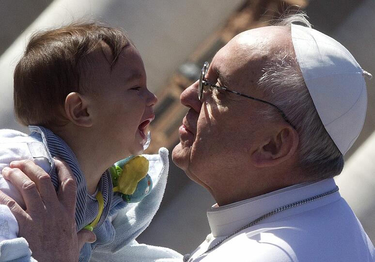 Der Papst ist ein Menschenfischer: Papst Franziskus küsst ein Kind auf dem Petersplatz.