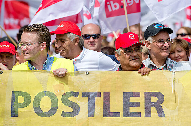 Mitarbeiter der Deutschen Post nehmen in München während einer Streikaktion an einer Demonstration teil.