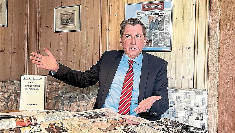 Bernhard Brunner vor Zeitungsausschnitten mit seinen F&auml;llen. F&uuml;r das Foto hat er sich extra einen Schlips umgebunden.