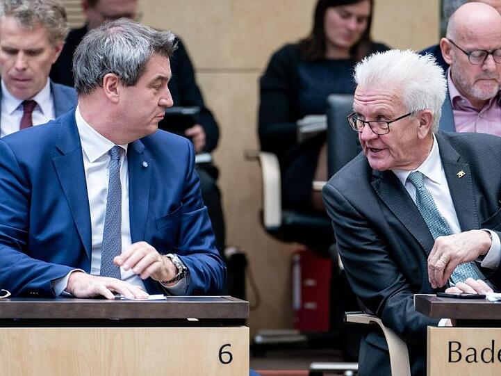 Markus Söder (l., CSU) und Winfried Kretschmann (Grüne) unterhalten sich während einer Sitzung des Bundesrats. Foto: Kay Nietfeld/Archiv