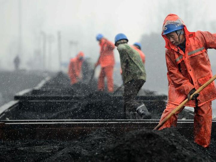 Das Archivbild zeigt Arbeiter auf einem mit Kohle beladenen Zug. China fördert weiter Kohle für seinen Energiebedarf - die Gruben gelten jedoch als sehr anfällig für Unglücke.