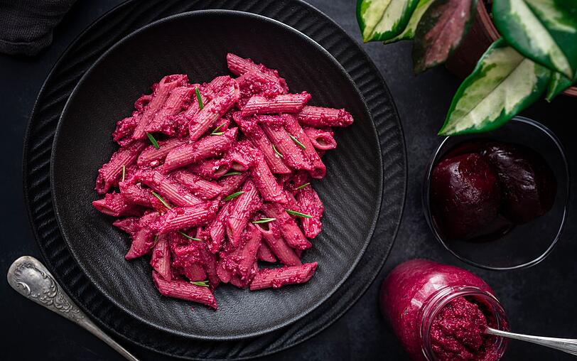 Rote Bete ist ein klassisches Wintergem&uuml;se und vor allem als eingelegte Salatzutat bekannt. Doch sie kann viel mehr. Bei diesem Pasta-Rezept f&uuml;r vier Personen sorgt sie f&uuml;r eine intensive Farbe und cremigen Geschmack. Heizen Sie zuerst den Ofen auf 200 Grad Umluft vor. Waschen Sie dann drei Rote-Bete-Knollen, viertlen Sie sie auf Alufolie und marinieren Sie sie mit einem Essl&ouml;ffel Oliven&ouml;l, Salz und Pfeffer.