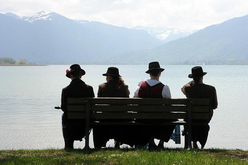 Die Mitglieder einer Trachtenblaskapelle genießen die wunderschöne Aussicht auf den Tegernsee.