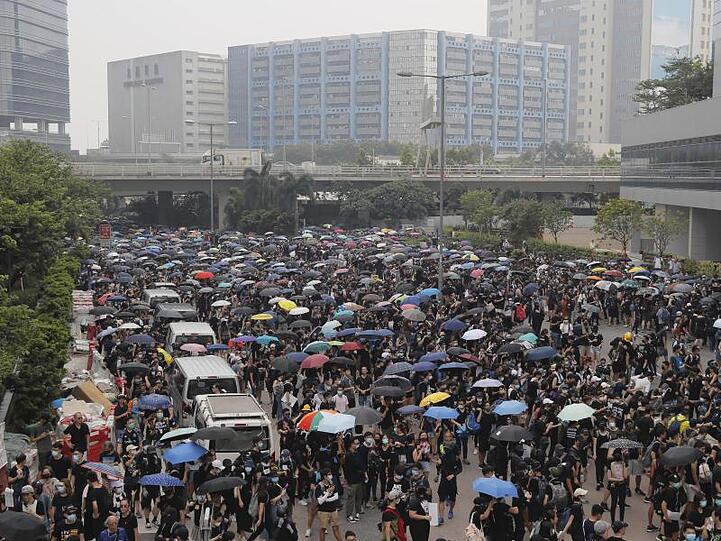 Demonstranten versammeln sich auf einer Straße. In Hongkong kommt es seit mehr als zwei Monaten immer wieder zu massiven regierungskritischen Protesten.