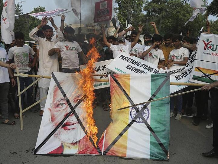 Pakistanische Demonstranten verbrennen bei einer Kundgebung in Lahore eine Fahne mit dem Bild des indischen Premierministers Modi.