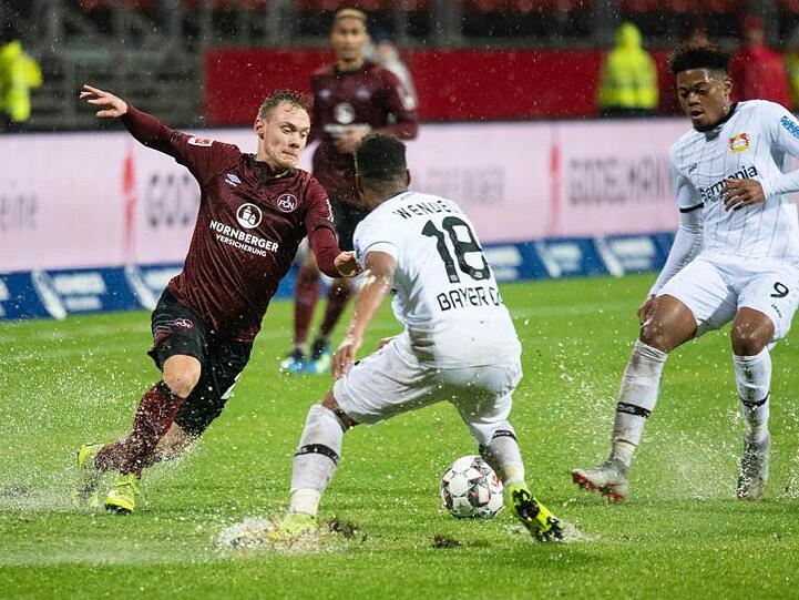 Nürnbergs Federico Palacios (l) kämpft mit Leverkusens Wendell (M) und Leon Bailey (r) um den Ball. Foto: Nicolas Armer