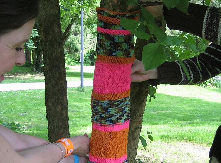 Bei der Aktion "Buntergiesing" stricken Linkshänder von Linkshänder e.V. bunte Überzüge für die Bäume.