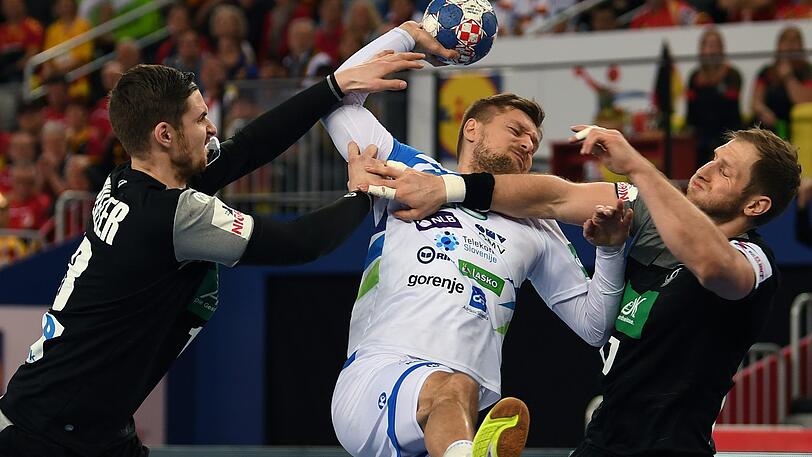 Deutschlands Hendrik Pekeler (l.) und Mannschaftskamerad Steffen Weinhold (r.) nehmen Sloweniens Marko Bezjak in die Zange.