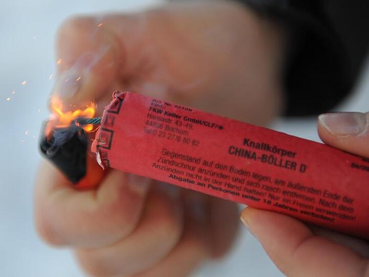 Ein Mann zündet einen Knallkörper der Klasse 2 an. Feuerwerk gehört für viele Menschen einfach zu Silvester dazu. Die Kehrseite zeigt sich alljährlich in Kliniken. Ärzte berichten von typischen und kuriosen Unfällen.