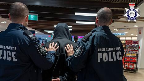 Polizisten führen den Schmuggler ab.