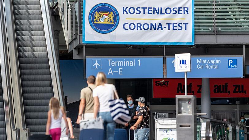 Reisende gehen am Flughafen München zum Corona-Test.