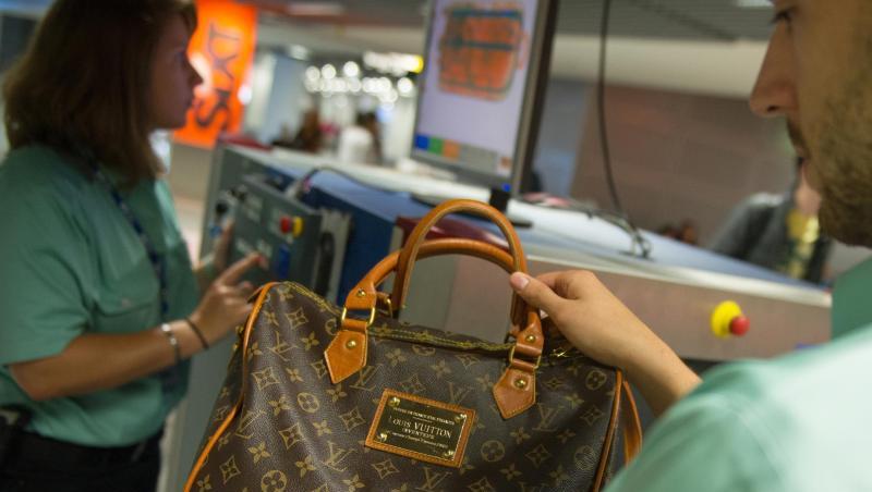 Flughafen Düsseldorf: Ein Zollbeamter hält eine gefälschte Louis-Vuitton-Handtasche in der Hand. Flughafen Düsseldorf: Ein Zollbeamter hält eine gefälschte Louis-Vuitton-Handtasche in der Hand.