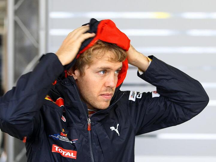 Sebastian Vettel informiert sich in der Boxengasse über die Wetterverhältnisse.