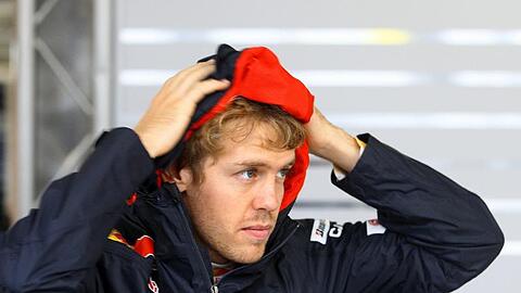 Sebastian Vettel informiert sich in der Boxengasse über die Wetterverhältnisse.