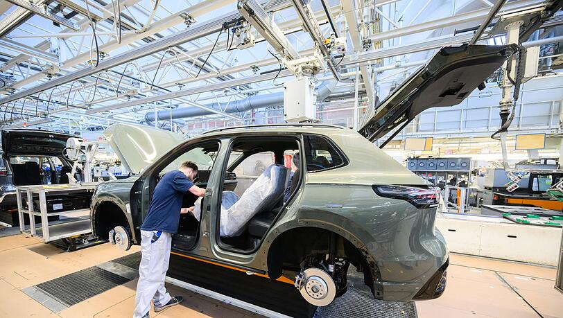 Mitarbeiter montieren in Wolfsburg den VW Tayron. (Archivbild)