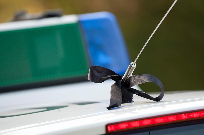 Einige Beamten haben schwarze Schleifen an die Antennen der Polizeiautos gebunden: Der Schock sitzt den Polizisten in den Knochen...