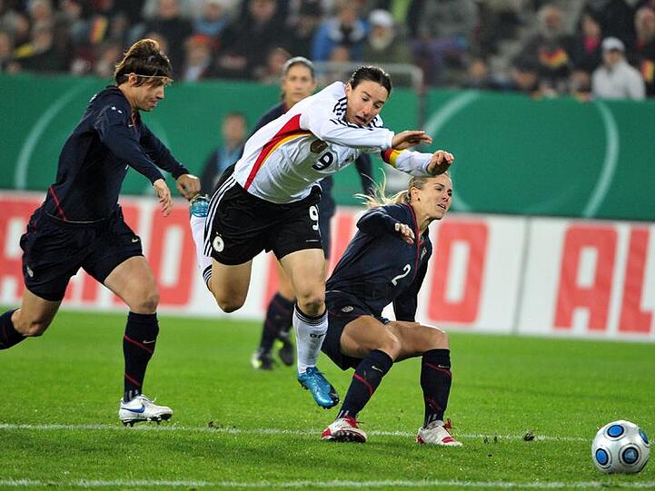 Birgit Prinz in der Zange von Amy LePeilbet (l.) und Heather Mitts.