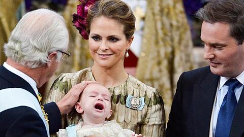 Schwedens König Carl Gustaf (l) bei der Taufe seinen Enkels Prinz Nicolas Paul Gustaf, der in den Armen von Prinzessin Madeleine liegt, rechts der Vater Christopher O'Neill.