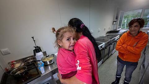 Zwei Frauen aus der Ukraine kochen in einem Küchenmodul der Erstanlaufstelle in Mammendorf bei Fürstenfeldbruck Essen auf einem Herd. dpa