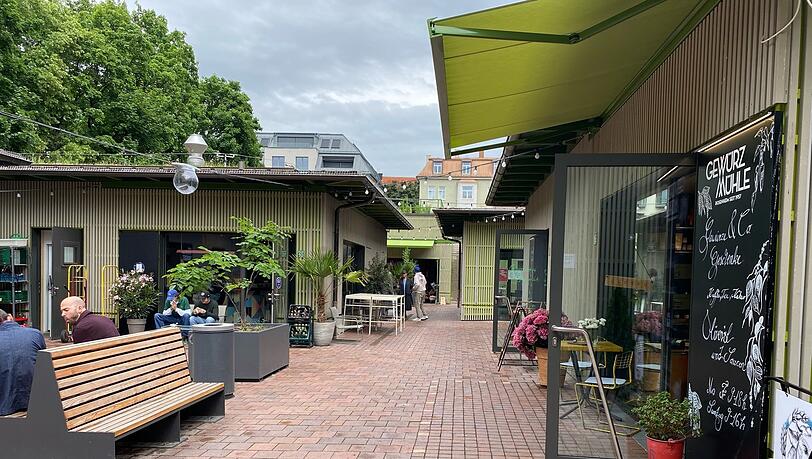 Der Schwabinger Elisabethmarkt mit seinen Neubau-Standln ist seit Herbst 2024 geöffnet. Hier ein Blick in einen der Innenhöfe mit Sitzgelegenheiten.