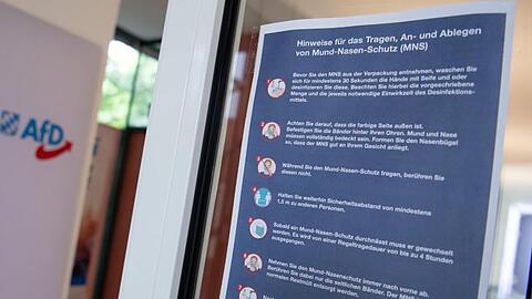 Eine Infotafel informiert über das Tragen, An- und Ablegen von Mund-Nasen-Schutz. Foto: Sven Hoppe/dpa