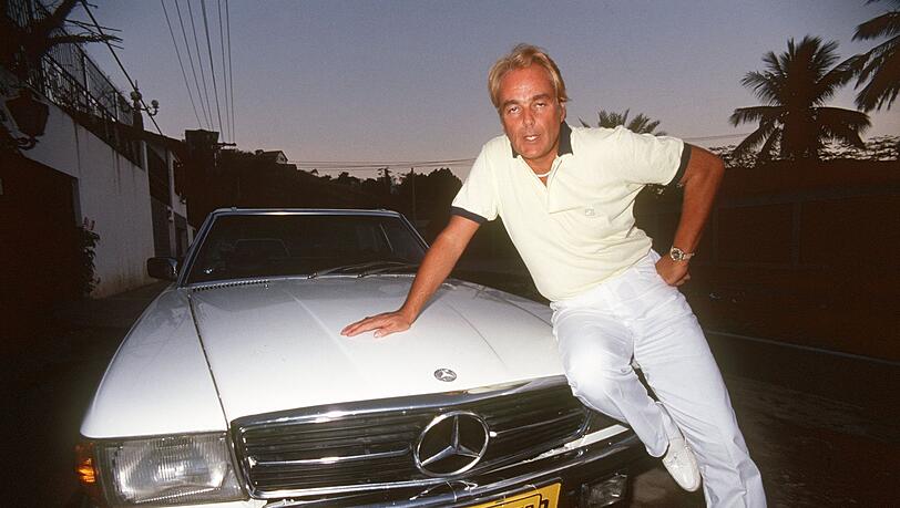 Hans-Hermann Weyer, bekannt durch den Verkauf von Titeln und Adelsprädikaten,  posiert neben einem Mercedes.