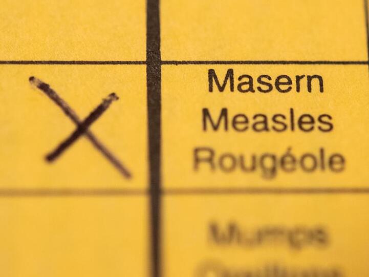 Ein Impfpass mit einem Kreuz bei der Masern-Impfung liegt auf einem Tisch.