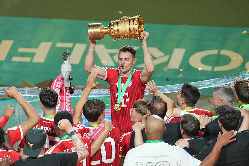 Josip Stanišić feiert mit Mitspielern und Pokal. Josip Stanišić feiert mit Mitspielern und Pokal.