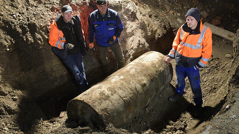 Nach der geglückten Entschärfung einer Fliegerbombe stehen am 25.12.2016 in Augsburg (Bayern) die Sprengmeister neben der Bombe.