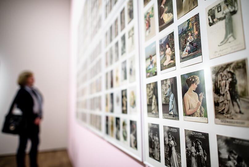 Eine Frau betrachtet in der Ausstellung "Du bist Faust - Goethes Drama in der Kunst" in der Kunsthalle eine Postkartensammlung von Jutta Assel und Georg Jäger aus den Jahre 1906 bis 1912. Die Postkarten zeigen zum größten Teil die Figur des Gretchens aus Goethes Drama.