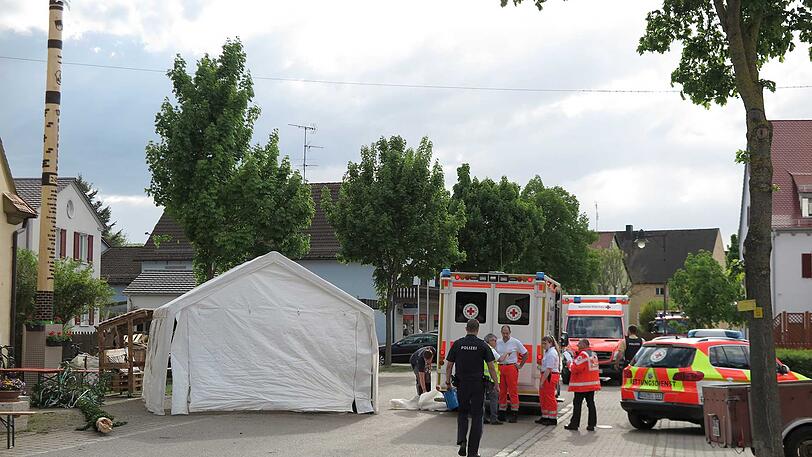Rettungskräfte im Einsatz neben dem Maibaum, dessen Spitze abbrach und die Frau erschlug.