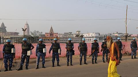 Ein Sadhu - ein hinduistischer Heiliger - geht in Ayodhya an Sicherheitsoffizieren vorbei. Der Streit zwischen Hindus und Muslimen um ein heiliges Areal hatte 1992 zu Ausschreitungen mit mehr als 2000 Toten geführt.