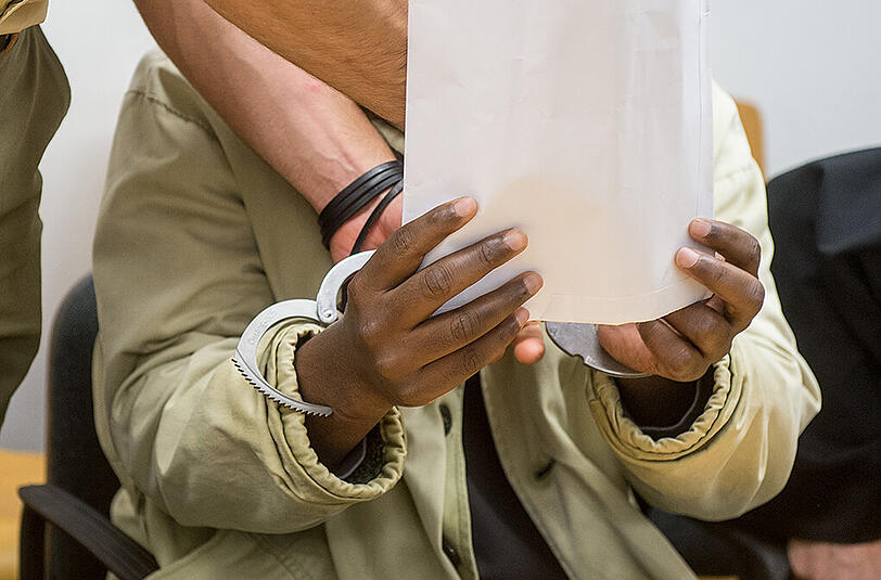 Dem Angeklagten Mohamed S. werden am Dienstag im Gerichtssaal des Landshuter Landgerichts von einem Polizeibeamten die Handschellen abgenommen.