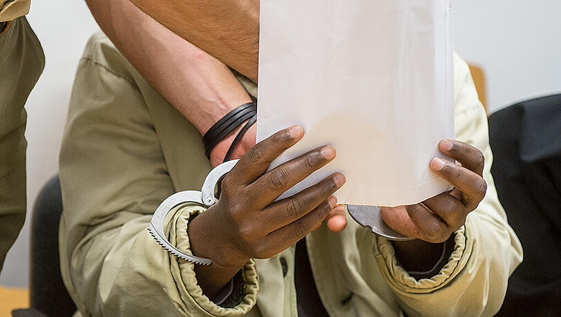 Dem Angeklagten Mohamed S. werden am Dienstag im Gerichtssaal des Landshuter Landgerichts von einem Polizeibeamten die Handschellen abgenommen. Dem Angeklagten Mohamed S. werden am Dienstag im Gerichtssaal des Landshuter Landgerichts von einem Polizeibeamten die Handschellen abgenommen.