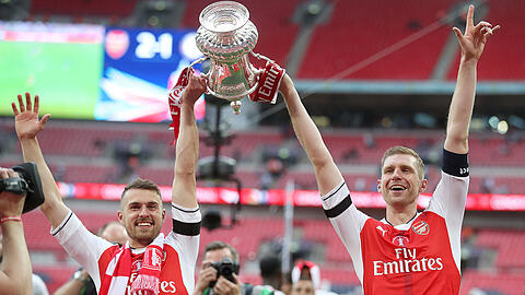 Arsenals Adam Davy (l) und sein deutscher Teamkollege Per Mertesacker jubeln mit dem Pokal nach dem Sieg.